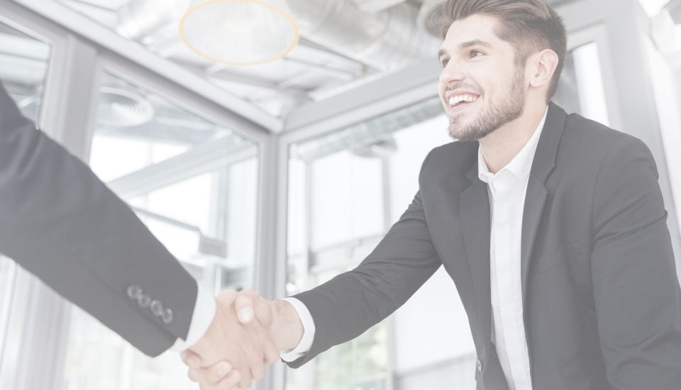 Zwei Männer in Anzügen geben sich die Hand